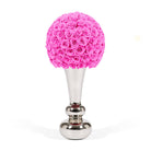 Decorative object with pink rose ball on a silver base against a white background