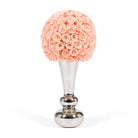 Decorative item with pink rose ball on a silver stand against a white background