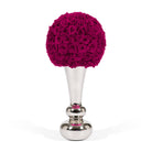 Decorative object with pink rose ball on a silver stand against a white background
