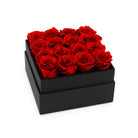 Black box filled with red roses on a white background