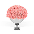 Bouquet of pink roses in a silver vase on a white background